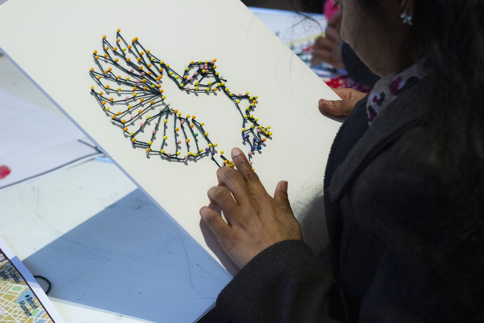 Child creating artwork of a bird.